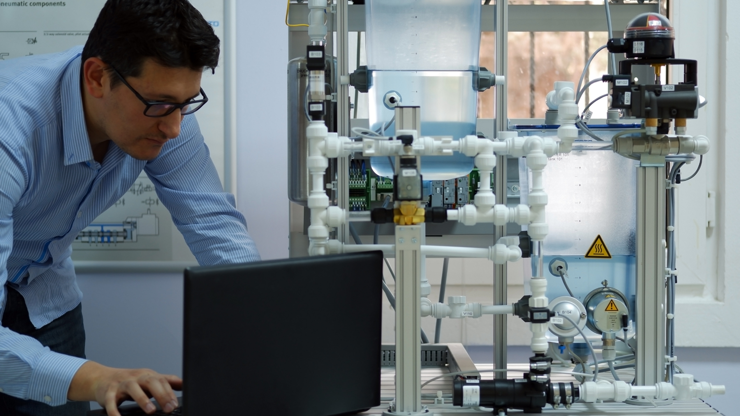 An engineer working on an industrial system with a laptop