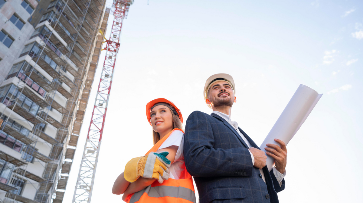 Civil engineers at construction site with building plans