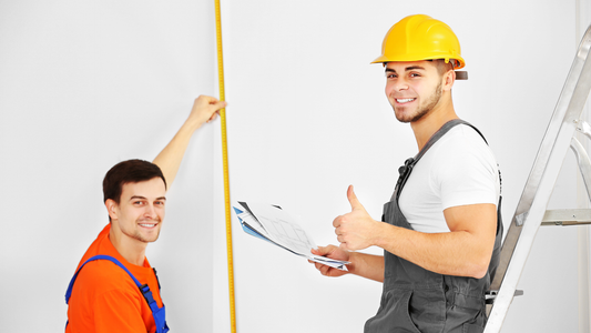 Construction workers reviewing building measurements and plans