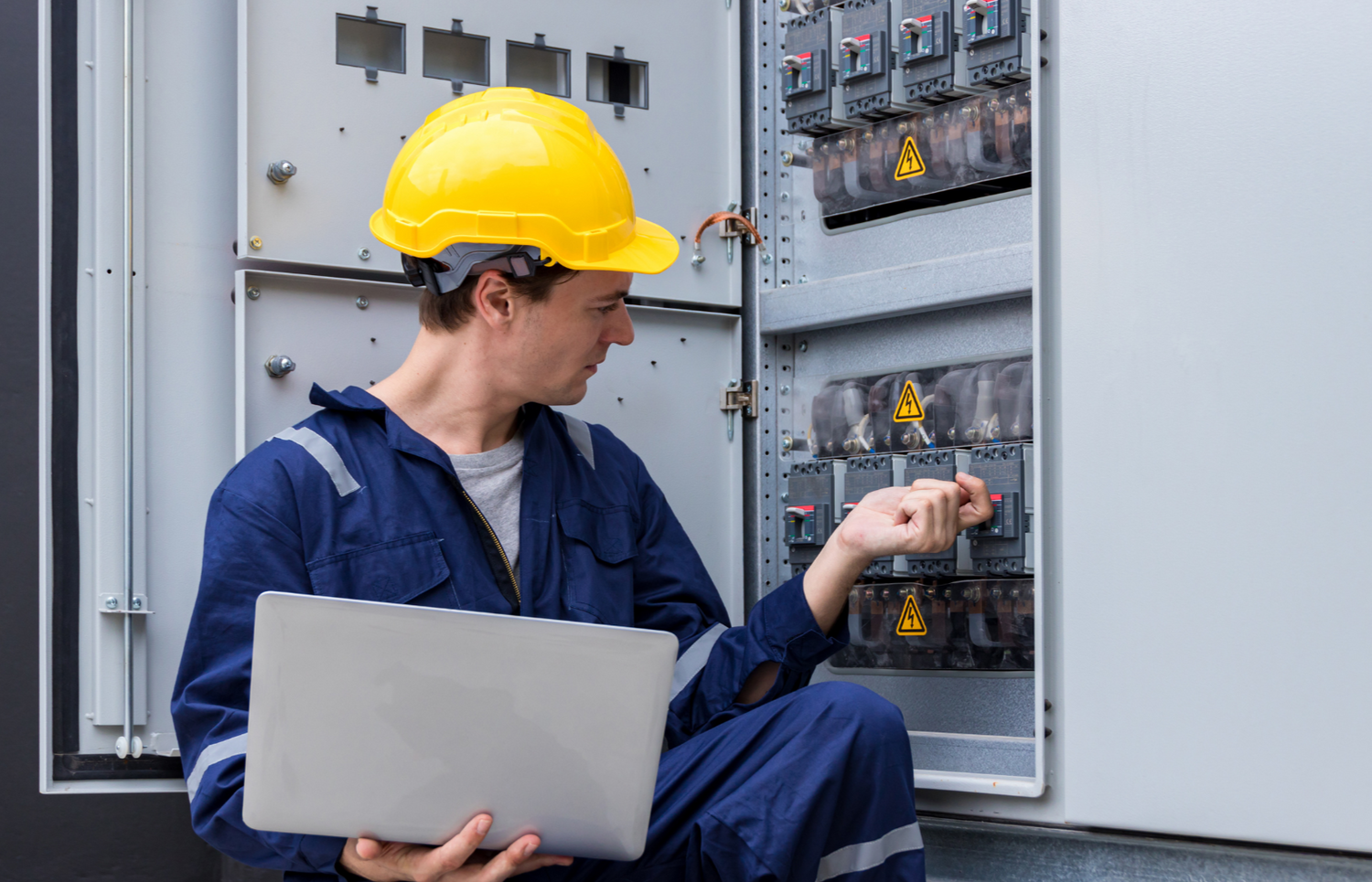 Controls engineer inspecting electrical control panel