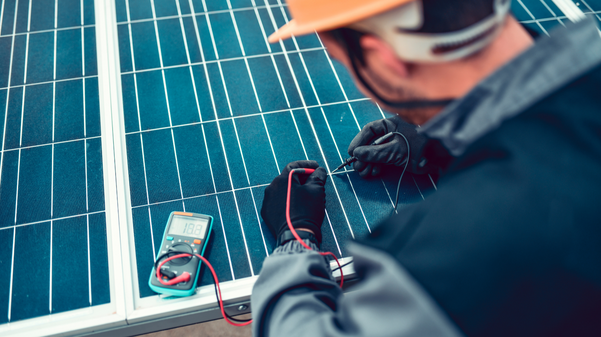 Engineer measuring solar panel electrical output