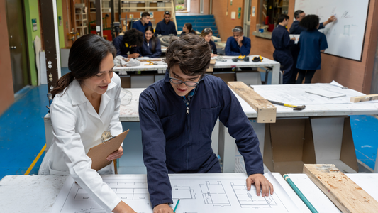 Engineering students collaborating on technical drawings