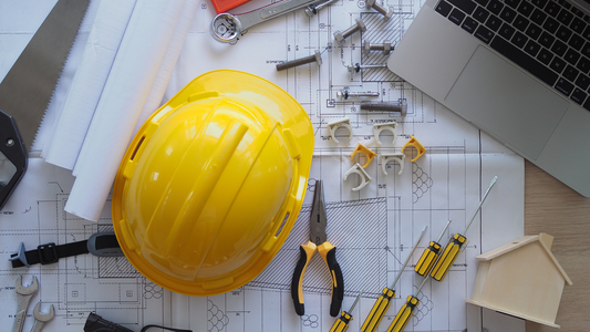 Engineering tools and hard hat on blueprints