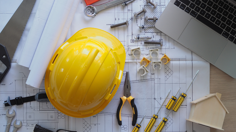 Engineering tools and hard hat on blueprints