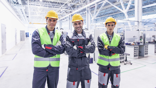 Engineers in industrial facility wearing safety helmets