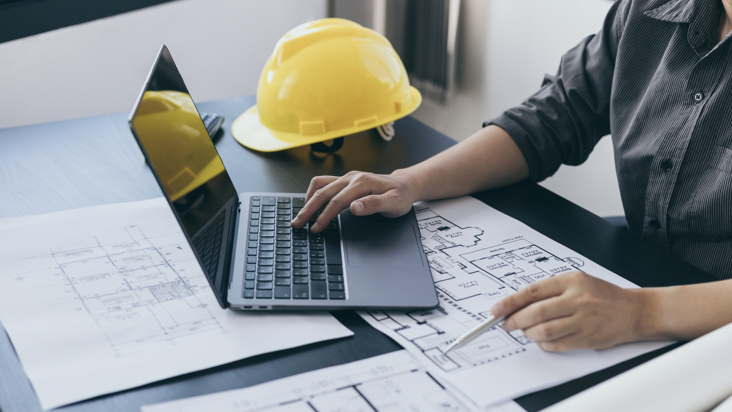 Engineers reviewing blueprints and plans at desk