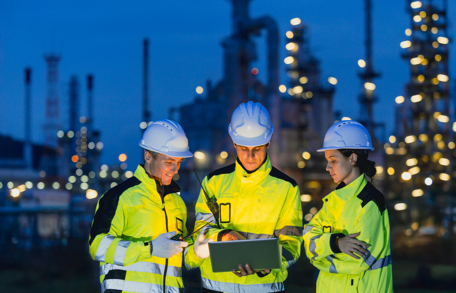Petroleum engineers reviewing data at an oil refinery